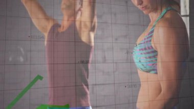 Kadın takip cihazını kontrol ediyor ve adam kettlebell kaldırıyor. Grafik çizelgeleri başlatılıyor. Vücut ölçüleri artıyor. Güç, fitness, egzersiz, eğitim, performans, egzersiz, teknoloji