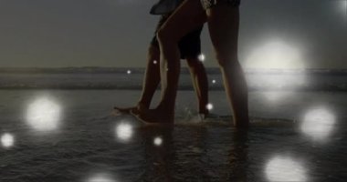 Gün batımında sığ sörflere adım atan çift su sıçratır ve turizmi canlandırır. Romantik, sakin, yalın ayak, boş zaman, manzara, sükunet, doğal