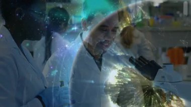 Kadın, pipetle laboratuvar örneği naklediyor. Dünya grafiği başlatılıyor ve erkek mikroskop kullanıyor. Bilim adamları, laboratuvar, araştırma, yenilik, kesinlik, işbirliği, moleküler