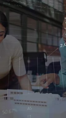 Animation of stock market data processing over two diverse women discussing over a plan at office. Global economy and business data technology concept