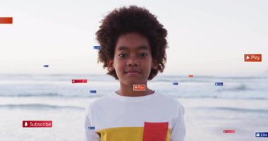 Sahil şeridinde sosyal simgelerle ayakta duran çocuk abone oluyor. Yörüngedeki baş gülümsemesi gibi oynuyorlar. Dijital, gençlik, umut verici, dinginlik, teknoloji, masumiyet