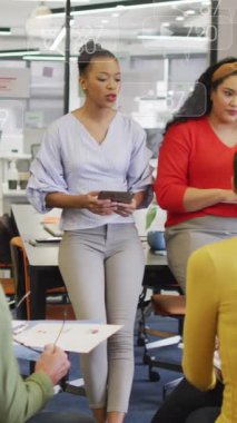 Sosyal medya simgelerinin, ofiste birlikte tartışan farklı meslektaşlardan oluşan bir ekip üzerinde toplanması. Sosyal medya ağı ve iş teknolojisi kavramı