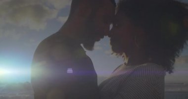 Güneş alçalırken okyanus dalgalarını seyreden gezgin çift, animasyon alevleriyle romantizmi paylaşıyor. Romantizm, samimiyet, günbatımı, kıyı şeridi, aşk, bağlantı, sükunet