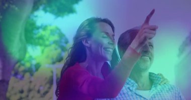 Yetişkin bir kadının, yapraklı parkta olgun bir erkeği kucakladığını, işaret ettiğini ve güldüğünü gösteren bir yaşam tarzı. Romantizm, bağlantı, sevgi, neşe, zarafet, samimiyet, mutluluk