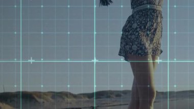 Seyahat reklamı için kumsalda şal toplayan bir kadın, hareketli rüzgarla şalı kaldıran bir esinti. Bohem, kıyı, kadınsı, esintili, günbatımı, boş zaman, açık hava