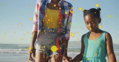 Anne çömeliyor, kaldırıyor ve döndürüyor, kız evlat, sarı parçacık sağlığa teşvik ediyor. Aile, açık hava, neşeli, neşeli, doğa, bağ, tasasız