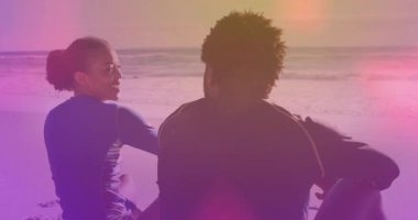 Kadın sörfçü, kollarını kaldıran adama doğru dönüyor. Dalgalanan fişeklerle sörf hayatı yaşıyor. Romantizm, sükunet, rahatlık, açık hava, macera, sükunet, bağlantı