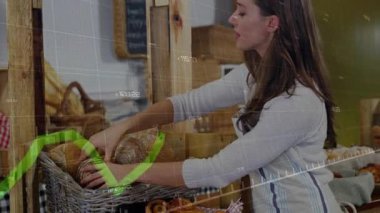 Ekmeği teftiş eden bir kadın fırında rulo düzenlerken, yeşil grafik satışlar yükseliyor. Fırın, zanaat, köy, konukseverlik, sunum, ticaret, minimalizm