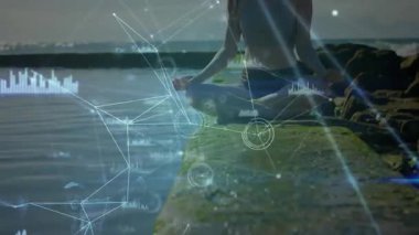 Grafikler ortaya çıkıyor ve kamera uzaklaşıyor meditasyon yapan bir kadının sağlık teknolojisi veri akışını gösterdiğini gösteriyor. Zen, sükunet, dijital, farkındalık, bağlantı, dinginlik, yenilik