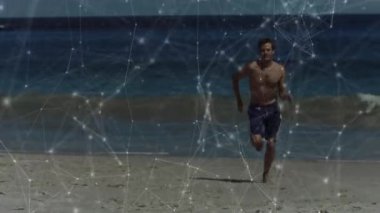 Tişörtsüz bir adam plaja adım atıyor, spor aletleri için koşarken ağ kaplamasını aktifleştiriyor. Atletizm, hareket, fitness, teknoloji, sahil, açık hava, dinamik