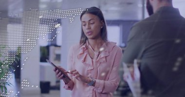 Pembe bluzlu bir kadın açık planlı ofiste tabletle etkileşime geçiyor. Dijital dünya haritası örtüşüyor. İşbirliği, yenilik, teknoloji, çalışma alanı, şirket, takım çalışması, dijital