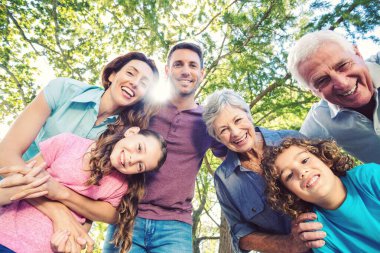 Parkta eğlenirken kameraya bakan mutlu, beyaz bir ailenin düşük açılı görüntüsü. Değiştirilmemiş, aşk, birliktelik, çocukluk, haftasonu, keyif ve emeklilik kavramı.