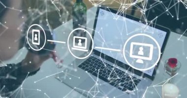 Şarap kadehi kaldıran orta yaşlı bir kadın teknoloji bağlantısını gösteren ikonları birbirine bağlamaya başlıyor. Teknoloji, iletişim, bağlantı, ev ofisi, dijital, ağ, rahatlama