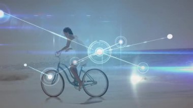 Islak plajda pedal çeviren kadın bisikletçi, kıyı şeridini kaplayan genişleyen teknoloji ağı üretiyor. Manzara, yenilik, bağlantı, dinginlik, rahatlık, fütüristik, açık hava