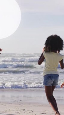 Sahildeki Afro-Amerikan ailesinin üzerindeki ışık noktalarının animasyonu. Yaşam tarzı ve boş zaman konsepti dijital olarak oluşturulmuş video.