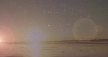 Şafakta kıyıya çıkan kadın dansçı, eşarp örüyor ve sağlık için ışıltı efektiyle zıplıyor. Huzur, gün doğumu, hareket, zarafet, sükunet, yansıma, açık hava