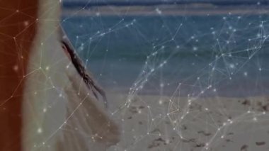 Plaj hamağına adım atan bir kadın kendini içeri çekiyor ve seyahat pazarlaması için güneşe doğru esniyor. Dinginlik, rahatlama, rahatlama, tatil, sahil, yaşam tarzı, minimalizm