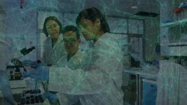 Laboratuar ekibi pipette örnekleme yapan bilim adamını izliyor ve animasyon çizelgesini inceliyor. Araştırma, yenilik, kesinlik, işbirliği, teknoloji, keşif, deney