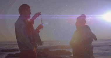 Baloncuklu değnek daldıran adam, sürüklenen baloncuk oluşturan kadın rehber olarak bebeği memnun eden adam. Aile, sahil, gün batımı, eğlence, bağlantı, boş zaman, açık hava.