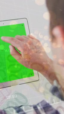 Red graph and sparks of light over caucasian man using digital tablet with copy space. Global networking and business data technology concept