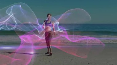 Fitness modeli plajda ağırlığını değiştiriyor, neon kurdeleleri fitness tanıtımı için sarmal sütunlara yönlendiriyor. Fitness, teknoloji, dinamik, modern, enerjik, sanat, hareket