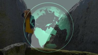 Dişi yürüyüşçü kanyon boşluğundan geçiyor ve haritalama için dönen teknoloji küresi örtüsü kullanıyor. Macera, keşif, dijital, teknoloji, doğa, seyahat, keşif