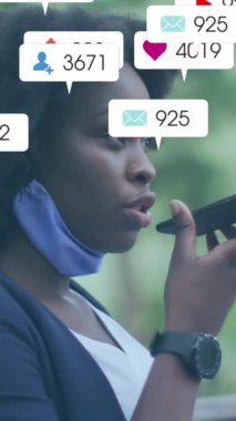 Animation of social media icons with growing numbers over african american woman using smartphone. Global social media, technology and digital interface concept digitally generated video.