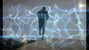 Erkek koşucu şafak vakti kıyı yolundan kareye giriyor ve zindelik için dalga grafiklerini aktifleştiriyor. Spor, fitness, çevre, manzara, hareket, ilham, kararlılık