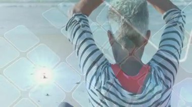 Sahilde kıdemli bir kadın kollarını kaldırıyor ve sağlıklı olmak için avuç içlerine katılıyor. Geometrik kaplama yoğunlaşıyor. Meditasyon, sükunet, farkındalık, dinginlik, rahatlama, refah, ruhsal