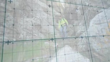 Kamera taraması ve teknolojik şebeke üzerine eğilme. Yürüyüşçülerin seyrüsefer için alçaldığını gösteriyor. Macera, engebeli, keşif, açık hava, esneklik, dağ, tek kişi