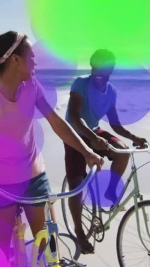 Sahilde yürüyen insanların üzerinde renkli bir bokeh animasyonu. Günbatımı, boş zaman, yaşam tarzı, açık hava, seyahat, kum