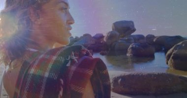 Gezgin tasarımcı, güneş ışığı çıkarken kayalık kıyı şeridinin kayan bacağının üzerinde duruyor. Bu da lenslerin hareket etmesine neden oluyor. Doğa, tefekkür, bohem, dinginlik, ışıltı, kıyı, manzara