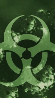 Yeşil arka planda yüzen çoklu covid-19 hücrelerinin üzerindeki biyolojik tehlike sembolü. Tıbbi acil durum ve covid-19 salgın konsepti