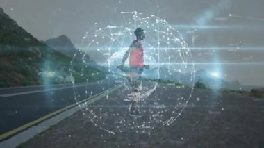 Şafakta kıyı şeridinde ip atlayan bir adam. Dönen veri küresiyle fitness takibi için. Sporcu, yenilik, fütüristik, teknoloji, açık hava, canlılık, hareket