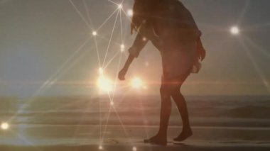 Gün batımında sahilde yürüyen bir kadın teknolojiyi etkinleştiriyor nesne seçiyor ve köpeği besliyor. Deniz kenarı, sükunet, minimalist, rüya gibi, ambient, açık hava, dinginlik