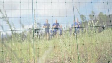 Altı koşucu spor yapmak için çayırda koşarken kamera odaklama ızgarası etkinleştiriliyor. Atletizm, takım çalışması, açık hava, manzara, enerjik, sağlıklı, yaşam tarzı