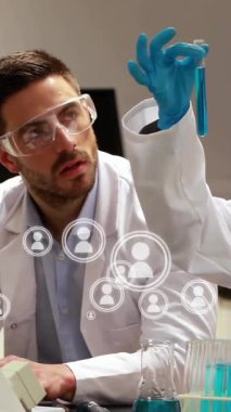 Bilgisayar ve test tüpleriyle çalışan laboratuvar önlüklü bilim adamları veri animasyonunu inceliyor. Bilim, laboratuvar, araştırma, analiz, teknoloji, deney