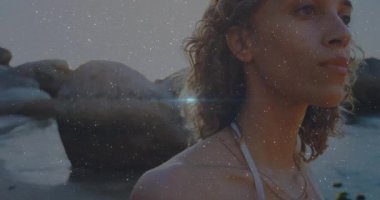 Gün batımında kıyıda dönen bir kadın. Dijital benekler sola kayıyor. Bu da reklam için mercek patlamasına neden oluyor. Manzaralı, karamsar, yansıtıcı, doğal, sinematik, sakin, sakin