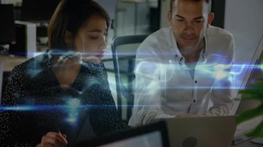 Kadın dizüstü bilgisayarda geziniyor, veri örtüsü oluşturuyor, erkek meslektaşı teknik analiz için çizelgeye bakıyor. İşbirliği, takım çalışması, dijital, yenilik, analiz, profesyoneller, ofis