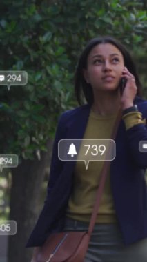 Şehirde akıllı telefon kullanan Asyalı bir kadın hakkında sosyal medya veri işleme animasyonu. Küresel hesaplama, dijital arayüz ve veri işleme kavramı dijital olarak oluşturulmuş video.