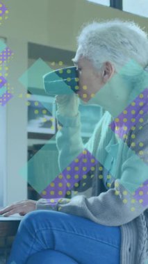 Kahve içerken dizüstü bilgisayar kullanan yaşlı beyaz kadının X sembollerinin animasyonu. Dijital bileşik, çoklu pozlama, işaretler, içecek, içecek, emeklilik ve teknoloji konsepti.