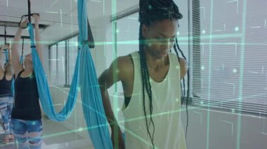 Sırtındaki ipeği emniyete aldıktan sonra, kadın yeşil AR ızgarası ile yoga dengesi kuruyor. Hava yogası, fitness stüdyosu, denge, esneklik, meditasyon, sağlık, modern