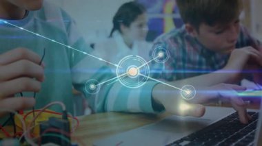 Çocuk devre kartına kablo yerleştiriyor. Sınıf arkadaşı da STEM 'in animasyon kodunu kullanıyor. Eğitim, teknoloji, yenilik, işbirliği, öğrenme, gençlik, fütüristik