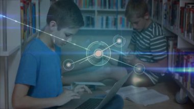 Çocuk dizüstü bilgisayarı açıyor ve kütüphane çalışmalarında ders kitabında zikzak çizerek ağ hareketlerini aktifleştiriyor. Teknoloji, işbirliği, eğitim, yenilik, dijital, öğrenme, gençlik