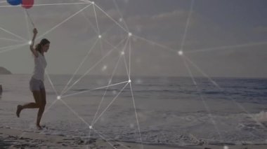 Sahil şeridi boyunca uzanan balonları tutan bir kadın sahile girerken teknolojik bağlantıyı gösteriyor. Deniz kenarı, canlılık, minimalist, dijital, tazelik, eğlence, bağlantı