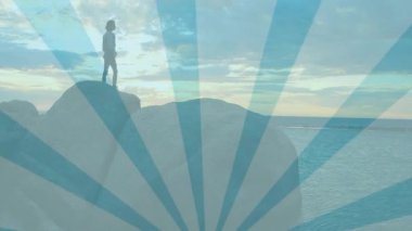 Gün batımında kayalık kıyı şeridine inmeden önce bir kadının şişeyi alıp yudumladığını gösteren bir seyahat reklamı. Macera, keşif, sükunet, doğa, açık hava, tefekkür, minimalist