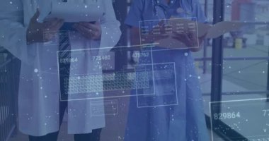 Veri panelleri koğuşta yüzerken doktorlar not yazarken hemşireler inceleme için dosya çeviriyor. Teknoloji, sağlık, yenilik, dijital, kesinlik, işbirliği, tanı