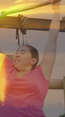 Engelli parkurunda asılı duran beyaz kadının günbatımının animasyonu. Küresel spor, sağlık, fitness ve dijital arayüz kavramı dijital olarak oluşturulmuş video.