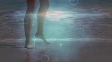 Holografik daireler girdap halinde girdap oluştururken kumda ayak basmaya başlayan dalga geri çekiliyor. Dijital, fütüristik, dolambaçlı, teknoloji, soyut, arayüz, yenilik