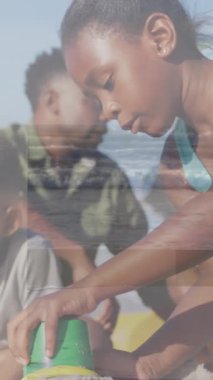 Sahildeki Afro-Amerikan ailesinin üzerindeki şekillerin animasyonu. Soyut arkaplan, aile ve tatil kavramı dijital olarak oluşturulmuş video.